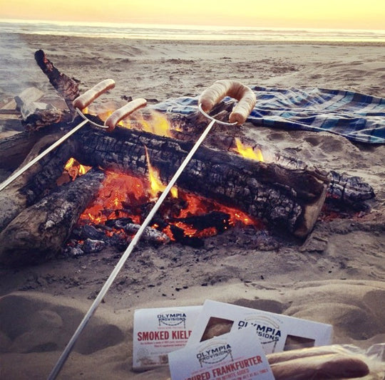 a bonfire on the Oregon coast with Olympia Provisions sausages roasting over it