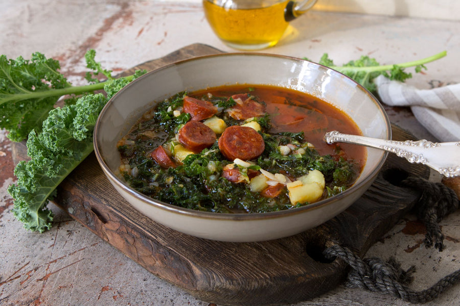 slices of chorizo on a bed of kale in a frying pan with