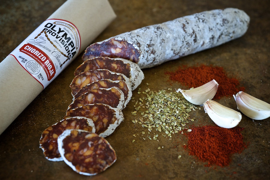 Olympia Provisions Chorizo Rioja sausage sliced up next to garlic and paprika